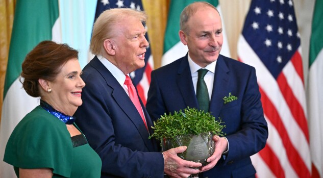 Irish Prime Minister Micheal Martin (R), with his wife Mary O'Shea (L), presents a bowl of shamrocks to President Donald Trump in the East Room of the White House on March 12, 2025.