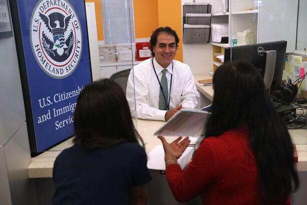A U.S. Citizenship and Immigration Services officer interviews applicants.
