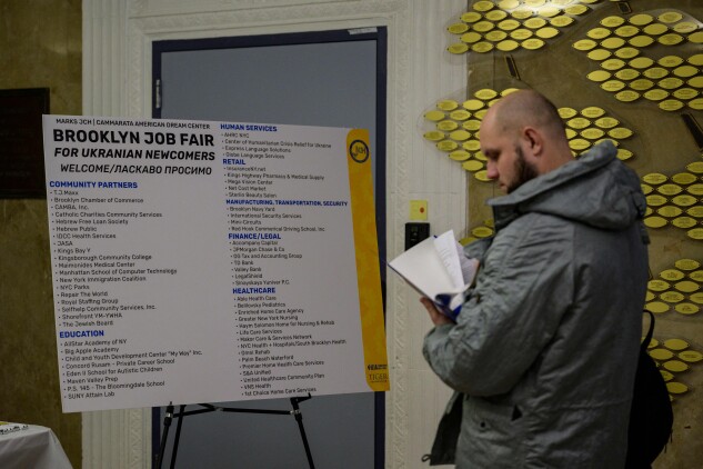 A Ukrainian refugee looks at paperwork as he attends a job fair in Brooklyn on Feb. 1, 2023.
