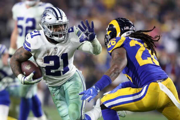 Ezekiel Elliott of the Dallas Cowboys runs with the ball against Mark Barron of the Los Angeles Rams in the NFC Divisional Playoff game at Los Angeles Memorial Coliseum on Jan. 12, in Los Angeles.