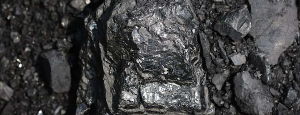 Photo of a large lump of coal on the ground.
