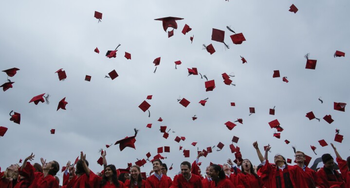 Graduating students toss their hats in the air at the conclusion of their commencement ceremony.