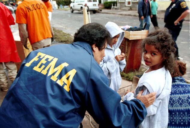 A FEMA worker helps a young flood victim in Bound Brook, N.J., on Sept. 22, 1999, after heavy rain from Hurricane Floyd hit the area.
