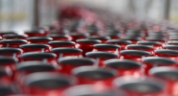 Empty Coca-Cola Classic cans move along a conveyor at a Coca-Cola production facility.