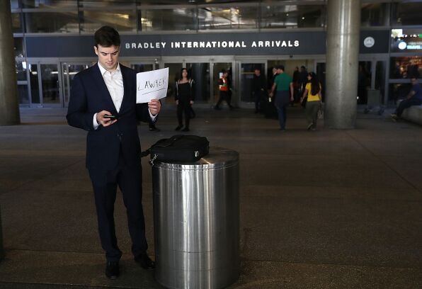 Lawyer holds a sign offering services outside Los Angeles International Airport.