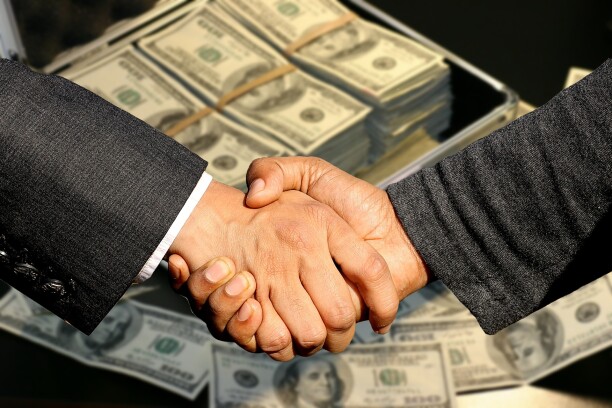 Shaking hands over a pile of money
Pay to Play