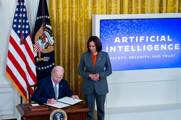 President Joe Biden signs an executive order on artificial intelligence regulation with Vice President Kamala Harris, right, during an event in the East Room of the White House in Washington, D.C., on Oct. 30, 2023. 