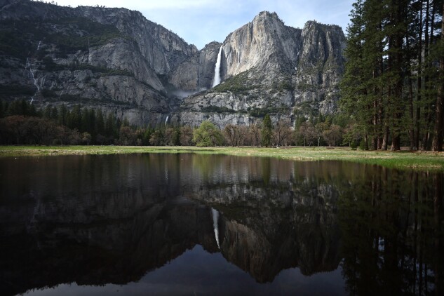Yosemite Falls is reflected in a partially flooded meadow April 30, 2023, as warm temperatures increased snowpack runoff. 