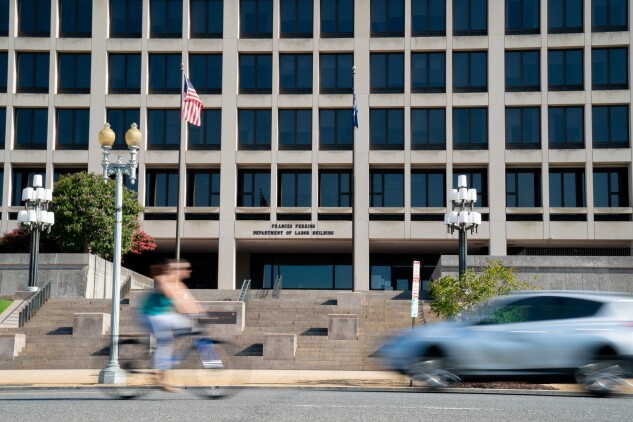 A cyclist rides past a U.S. Labor Department building in Washington, D.C., on Aug. 18, 2020.