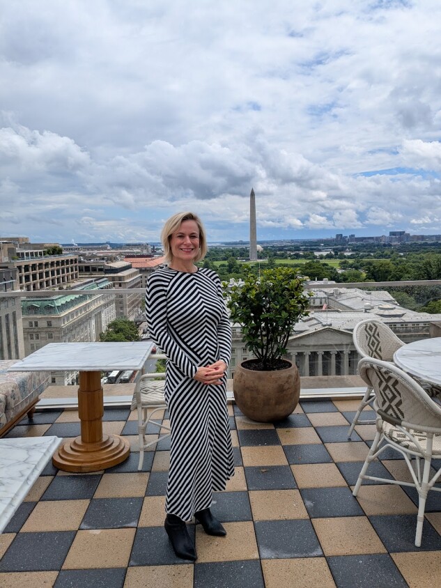 Joiwind Ronen, executive director of membership and programming at Ned's Club, stands on a terrace at the club with a view of the Washington Monument.